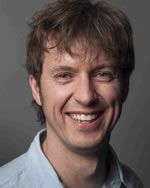 Headshot of young white man with brown hair, smiling