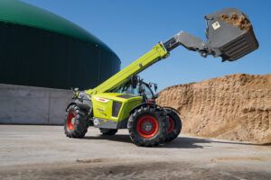 The Claas Scorpion 848 telehandler lifting a bucket filled with dirt or sand