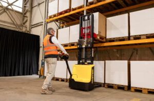 The SC1.2 pallet stacker lifting boxes in a warehouse