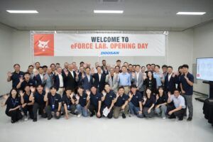 The eForce Lab inauguration event with Doosan Bobcat employees smiling at a camera