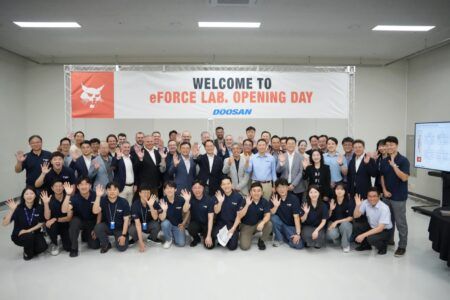 The eForce Lab inauguration event with Doosan Bobcat employees smiling at a camera