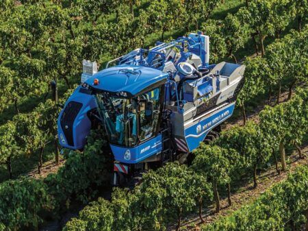 Aerial view of blue grape harvester in a field
