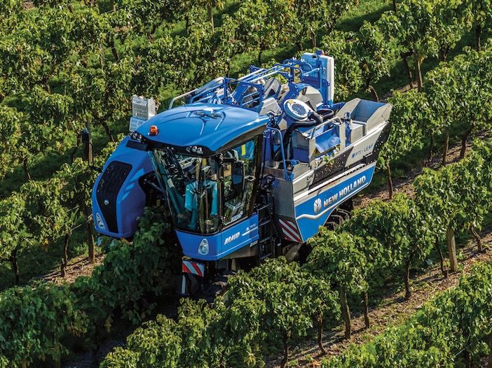 Aerial view of blue grape harvester in a field