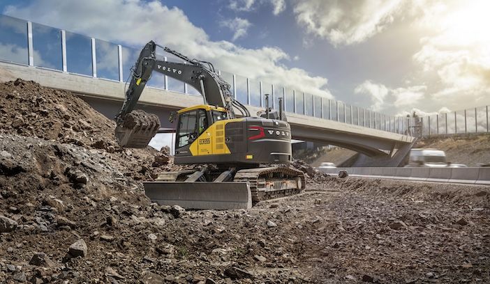 Volvo CE launches new ECR355 compact excavator Volvo CE ECR355 compact excavator performing earthmoving work adjacent to highway overpass, demonstrating short swing radius capabilities in confined space
