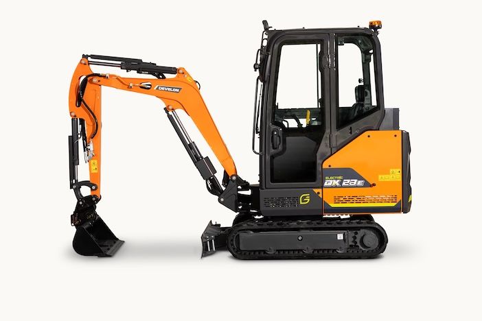  Studio profile shot of the Develon DX23E-7 electric mini-excavator in orange and dark grey livery, showing the enclosed cab, boom, arm and bucket on a white background