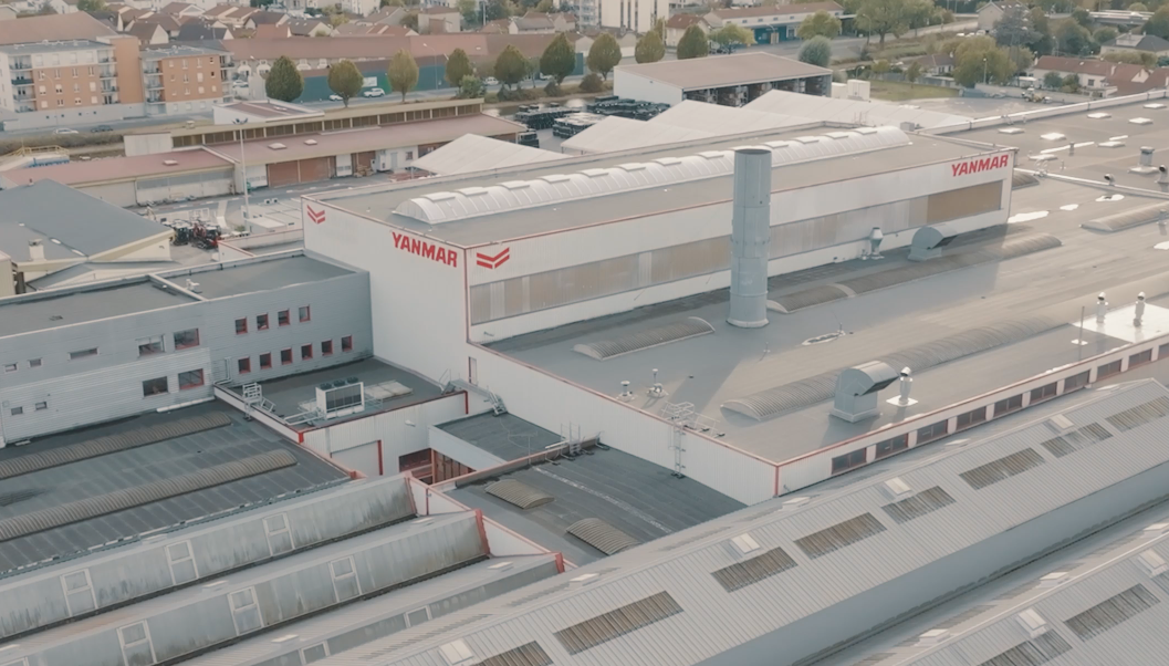 Aerial view of Yanmar CE's Saint-Dizier facility, showing the main production buildings with Yanmar branding and surrounding industrial infrastructure.
