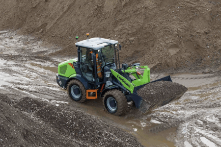 CONEXPO: LiuGong electric machines lead new launches A LiuGong 820TE battery-electric wheel loader in green livery loading aggregate on a muddy construction site