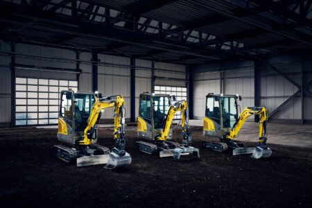 Wacker Neuson reveals redesigned mini excavators and remote-controlled trench roller Three yellow and grey Wacker Neuson mini-excavators lined up inside a warehouse, each fitted with a bucket attachment