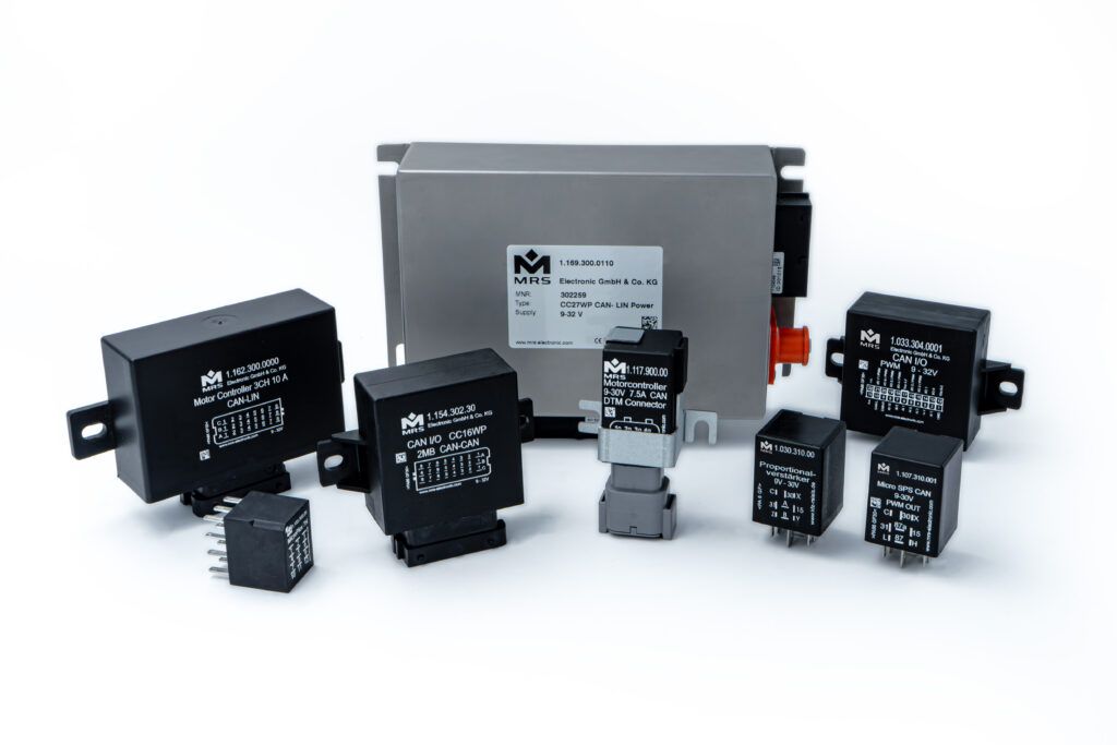  group of MRS Electronic electronic control units and modules arranged on a white background, including compact black CAN controllers, a larger grey enclosure unit and various relay and I/O devices