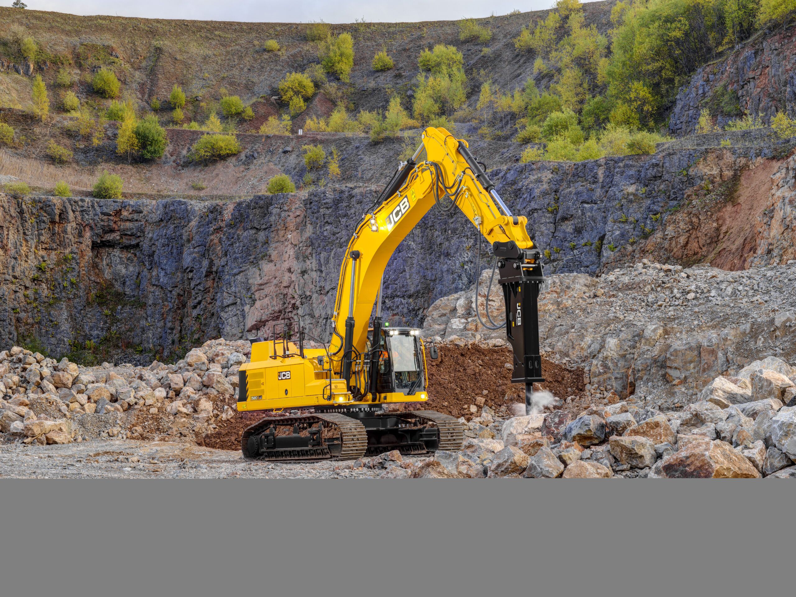 JCB 520X crawler excavator working amongst broken rock in a quarry