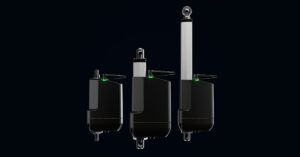 Three Linak LA21 electric actuators of varying stroke lengths shown side by side against a dark background, each with green status indicators illuminated