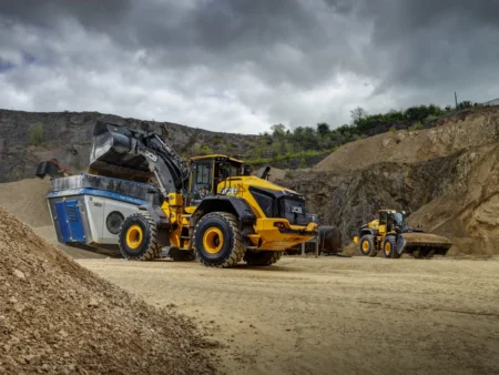 JCB previews new 480 and 490 wheeled loaders at Hillhead 2026 JCB 490 large wheeled loader tipping material into a crusher at a quarry, with a second JCB machine working in the background.