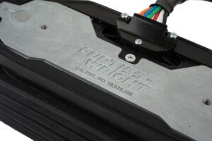 Detail of the Curtiss-Wright WM-G75 rocker pedal showing the embossed manufacturer name, US patent number and a colour-coded wiring harness exiting a sealed connector