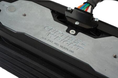 TECHNOLOGY PROFILE: Designing the next-generation of operator controls for off-highway OEMs Detail of the Curtiss-Wright WM-G75 rocker pedal showing the embossed manufacturer name, US patent number and a colour-coded wiring harness exiting a sealed connector