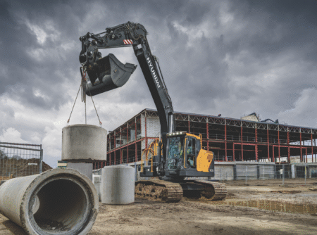 Hyundai launches HX210 crawler excavator at the Hillhead Hyundai HX210L Next Generation crawler excavator lifting a concrete ring using a clamshell bucket attachment on a construction site
