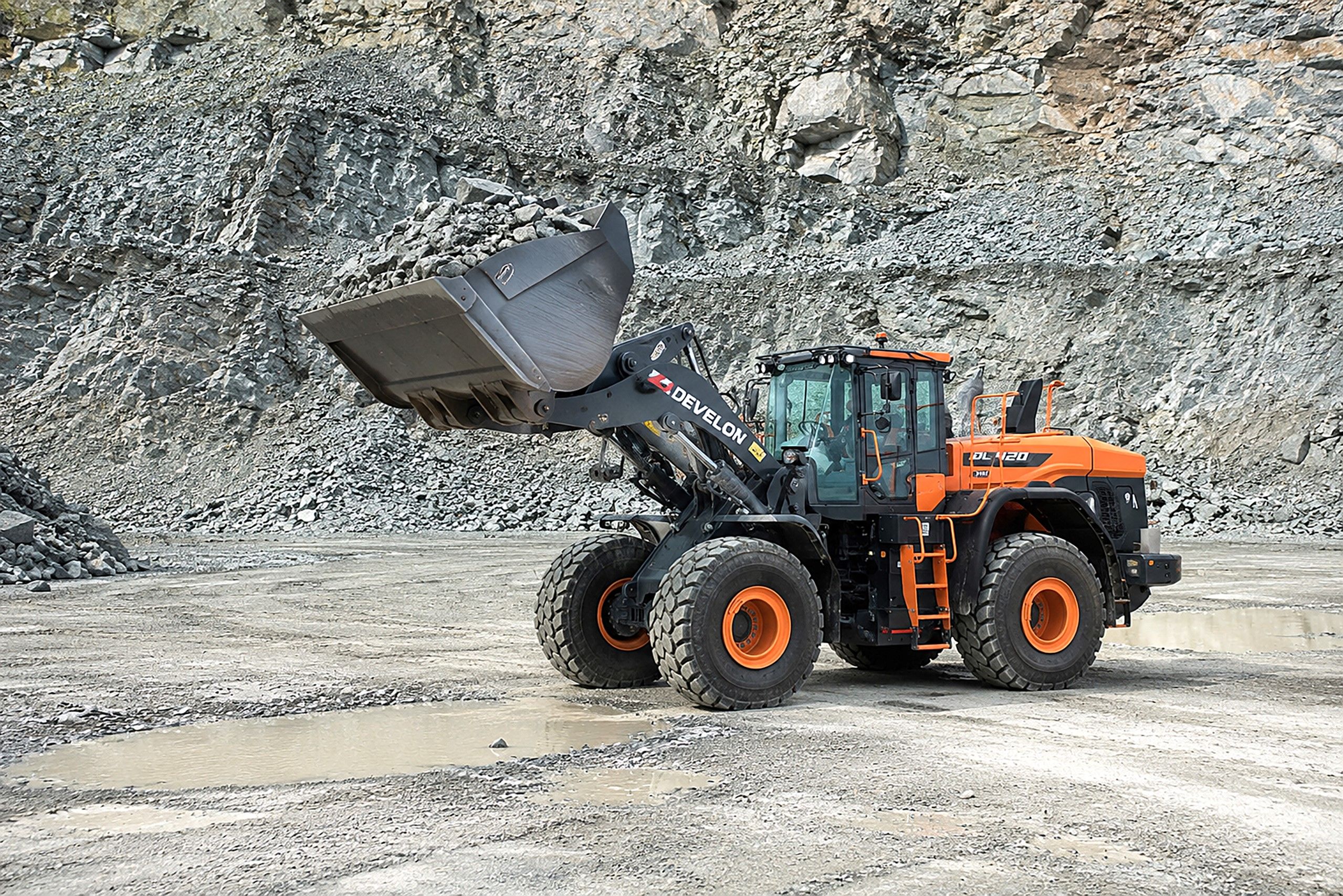 Develon DL420 wheel loader with a raised bucket in a quarry