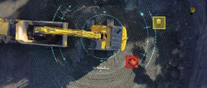 Overhead view of a Komatsu crawler excavator with digital detection markers highlighting nearby workers on a construction site