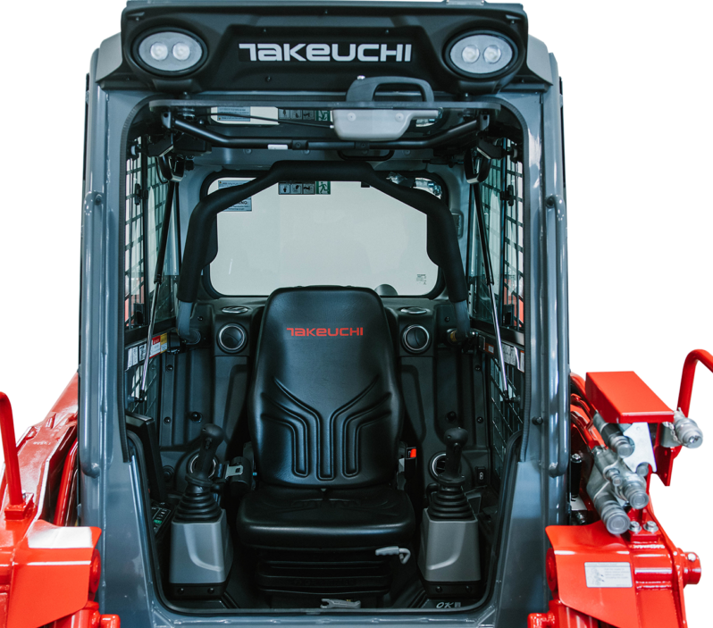 Interior view of a Takeuchi TL11R3 cab showing the suspension seat and joystick controls