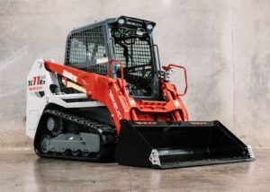 Front three-quarter studio view of a Takeuchi TL11R3 compact track loader with the bucket attachment lowered