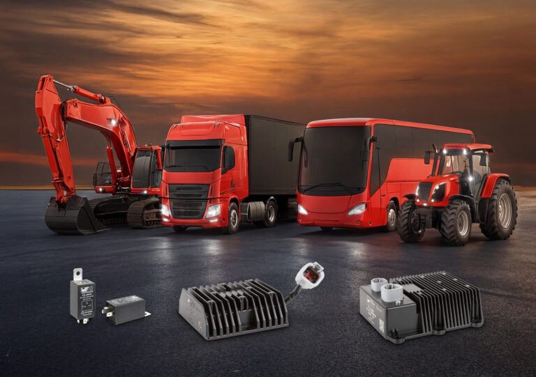 Four Würth Elektronik ICS DC/DC converter modules of varying sizes displayed in front of a red excavator, truck, coach and tractor
