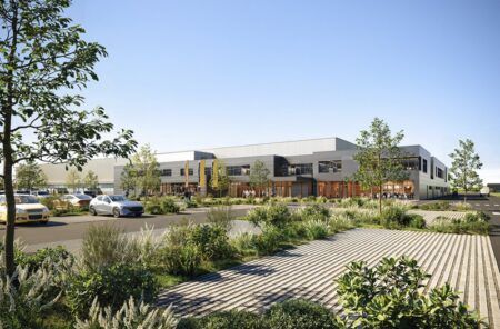 Architectural rendering of the new Liebherr Nambsheim facility, a long low industrial building with landscaped grounds under a blue sky
