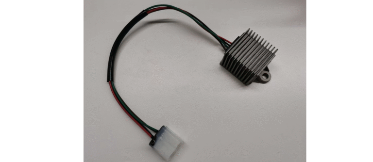 A finned aluminium DC/DC converter with a mounting lug and a wiring harness terminating in a white connector, shown on a plain background.