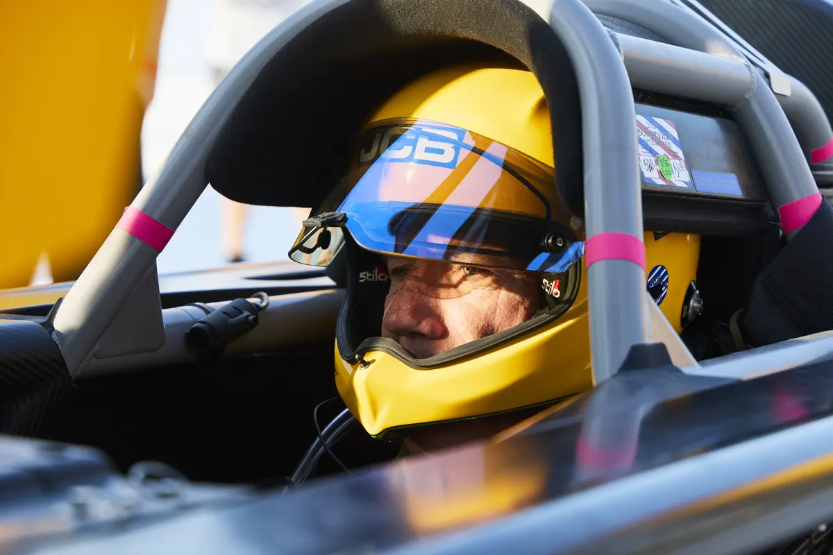 Helmeted driver seated in the JCB Hydromax cockpit