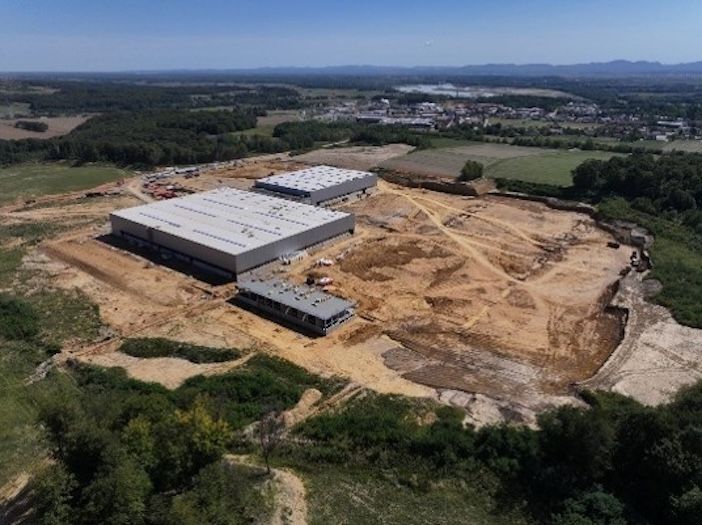Aerial view of the partially built Palfinger production facility in Ormož, showing large industrial buildings, excavation work and surrounding fields