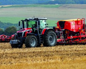 Red Massey Ferguson 7S Mark 2 tractor with front ballast weight working across a stubble field, side view.