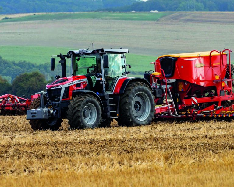 Red Massey Ferguson 7S Mark 2 tractor with front ballast weight working across a stubble field, side view.