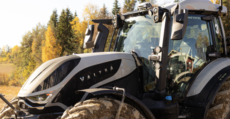 Valtra partners with PerPlant to offer factory-fitted AI crop sensing A high-specification Valtra tractor in silver and black parked at the edge of a field in autumn, with camera and sensor pods and work lights mounted on the cab roof.